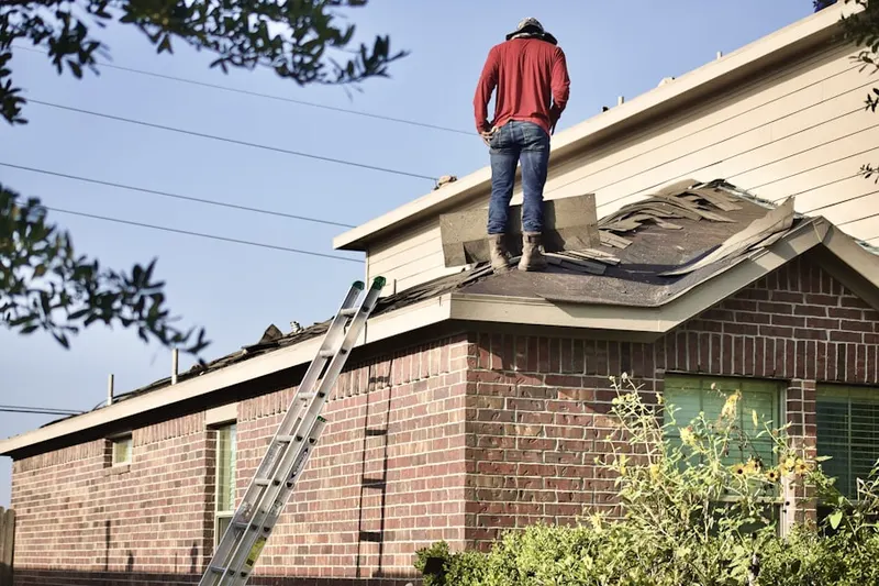 Professional roofer working on a residential roof in Briar Manor